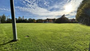 Hohes, grünes Fußballfeld bei Sonnenuntergang, ideal für Fußballferien mit der Hans Dorfner Fußballschule, um Fußballfähigkeiten in einer professionellen Umgebung zu verbessern.