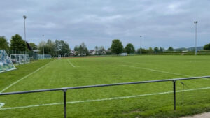 Leeres Fußballfeld mit Trainingsequipment und umliegender Natur bei Hans Dorfner Fußballschule in Deutschland.