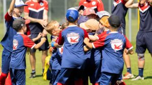 Kinder beim Fußballtraining, Spaß bei der Hans Dorfner Fußballschule, junge Fußballer trainieren auf dem Platz, Gruppenspirit, kindgerechte Fußballschule in Deutschland.