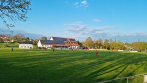 Grundschule mit Solardach und Fußballplatz, bei dem die Hans Dorfner Fußballschule für Kinder und Jugendliche im Einsatz ist, im sonnigen Ambiente.